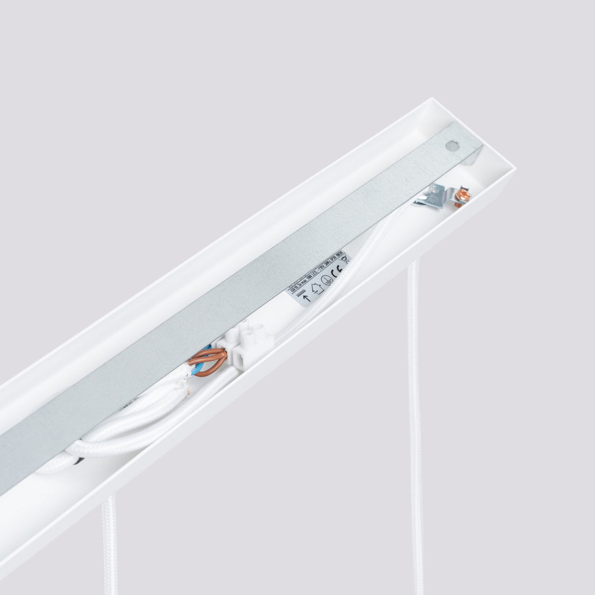 Détail technique de la platine de fixation avec câblage, bornier et étiquettes de conformité.