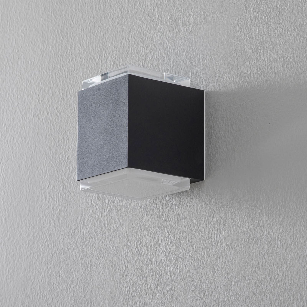 Vue de face de l'applique cubique noire éteinte, verre transparent en haut et bas