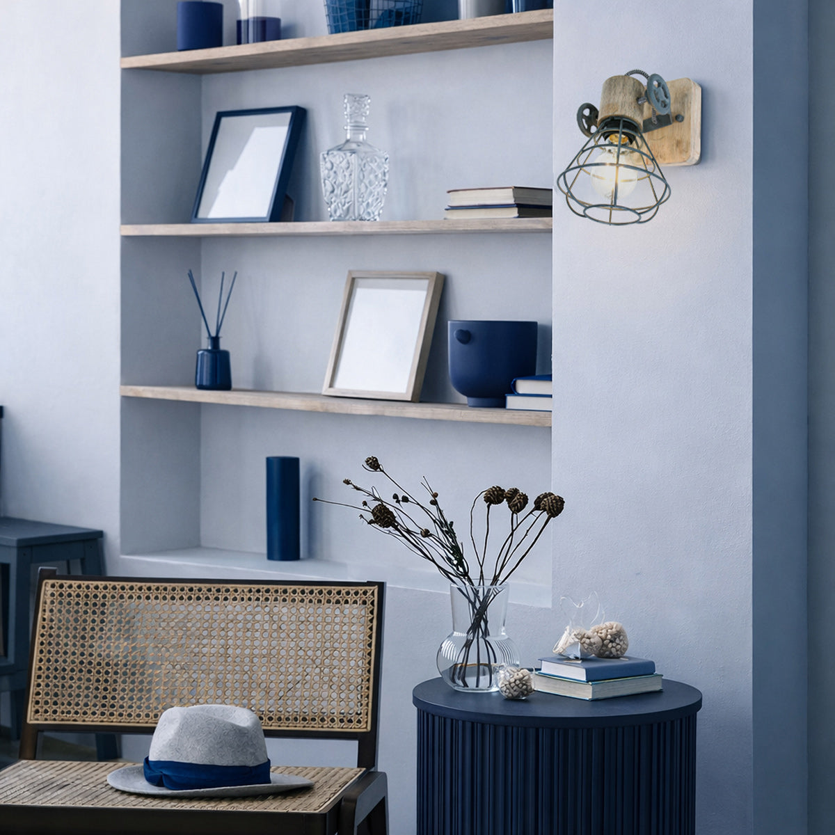 Mise en ambiance : applique murale allumée fixée au mur, près d'une étagère bleue décorée.