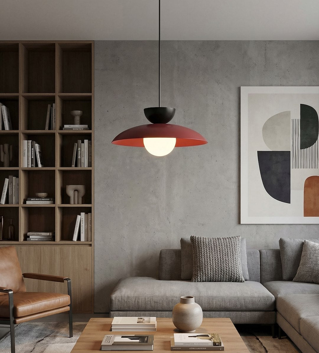 Mise en ambiance salon, luminaire suspendu devant bibliothèque en bois et mur béton gris