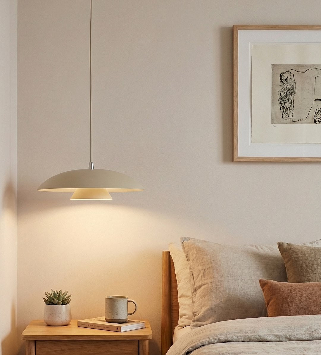 Mise en ambiance au-dessus d'une table de chevet, lumière chaude sur le mur.