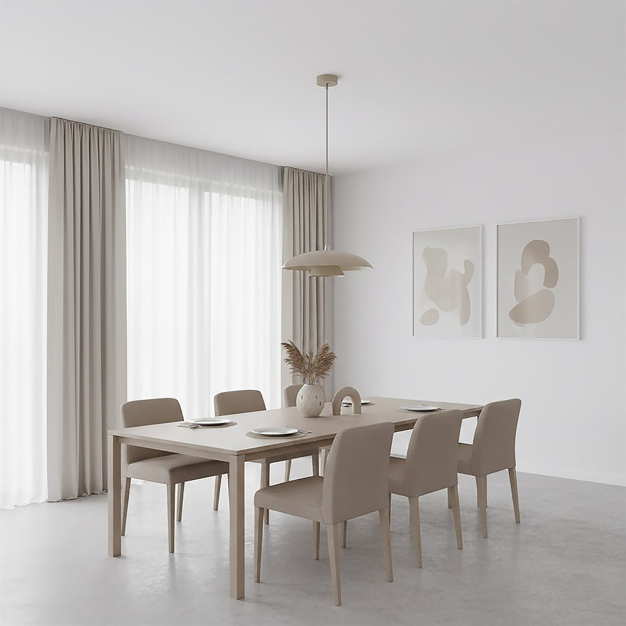 Autre vue de la salle à manger, rideaux beiges et table dressée sous la suspension.