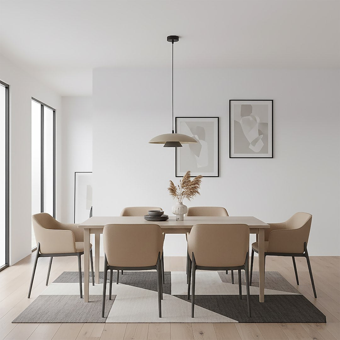 Suspension éclairée suspendue au-dessus d'une table dans un intérieur clair avec cadres