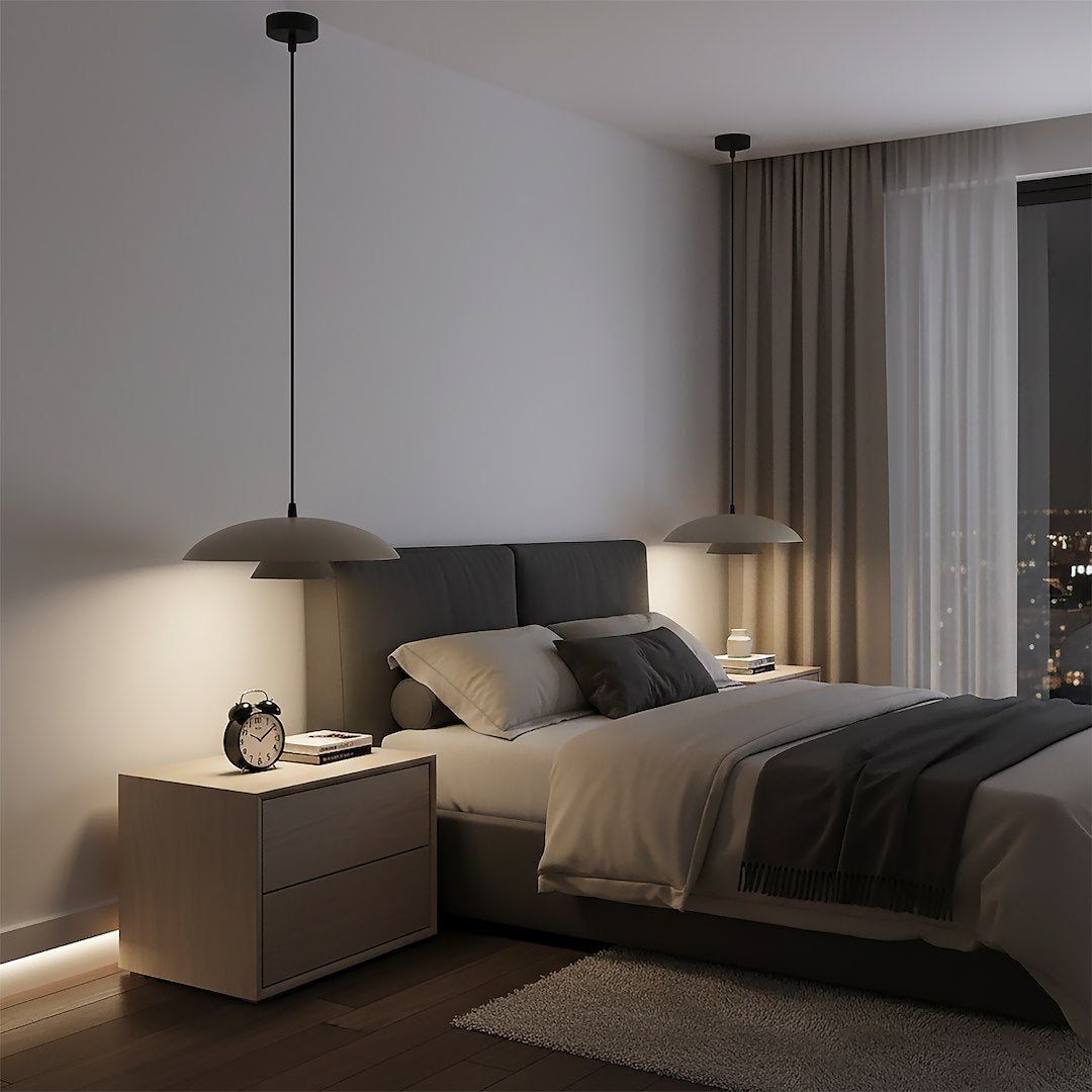 Deux suspensions beiges installées de chaque côté du lit dans une chambre