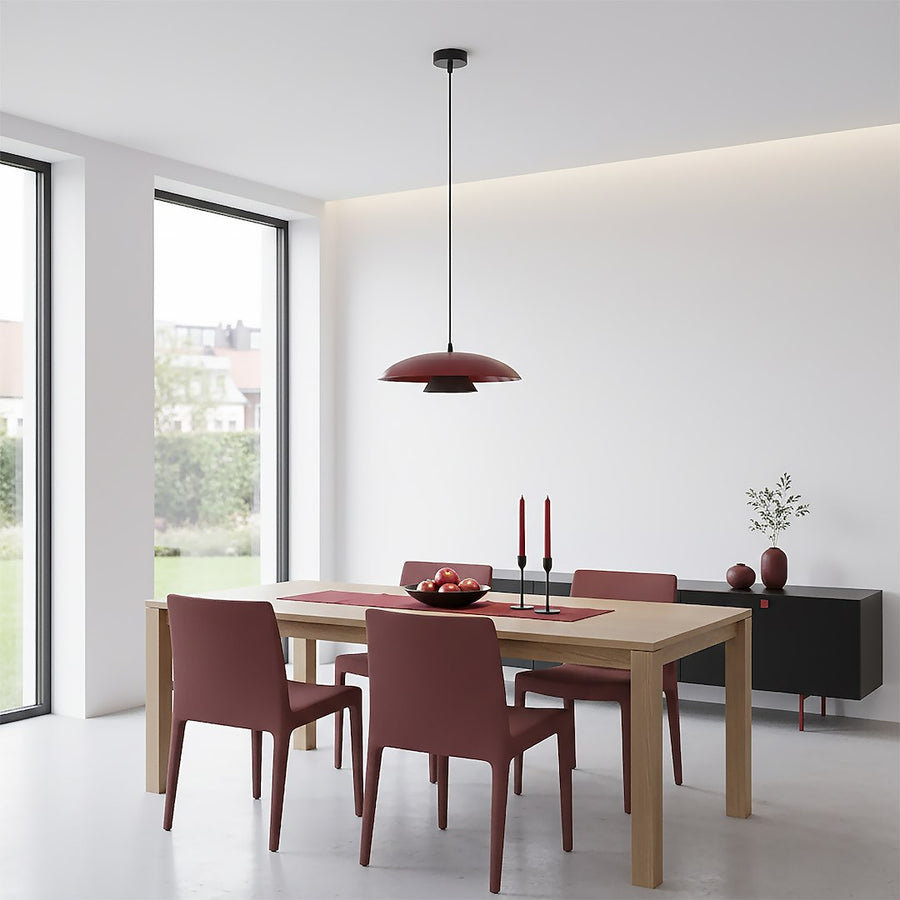Salle à manger lumineuse, abat-jour bordeaux suspendu au-dessus d'une table en bois clair
