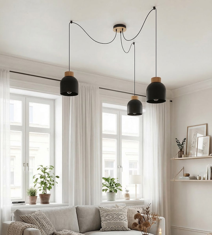 Suspension installée dans un salon lumineux devant des fenêtres à rideaux blancs.
