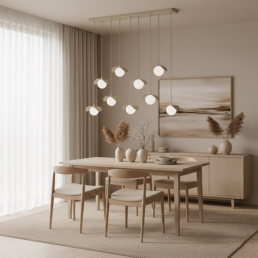 Luminaire suspendu au-dessus d'une table dressée, grands rideaux et tableau