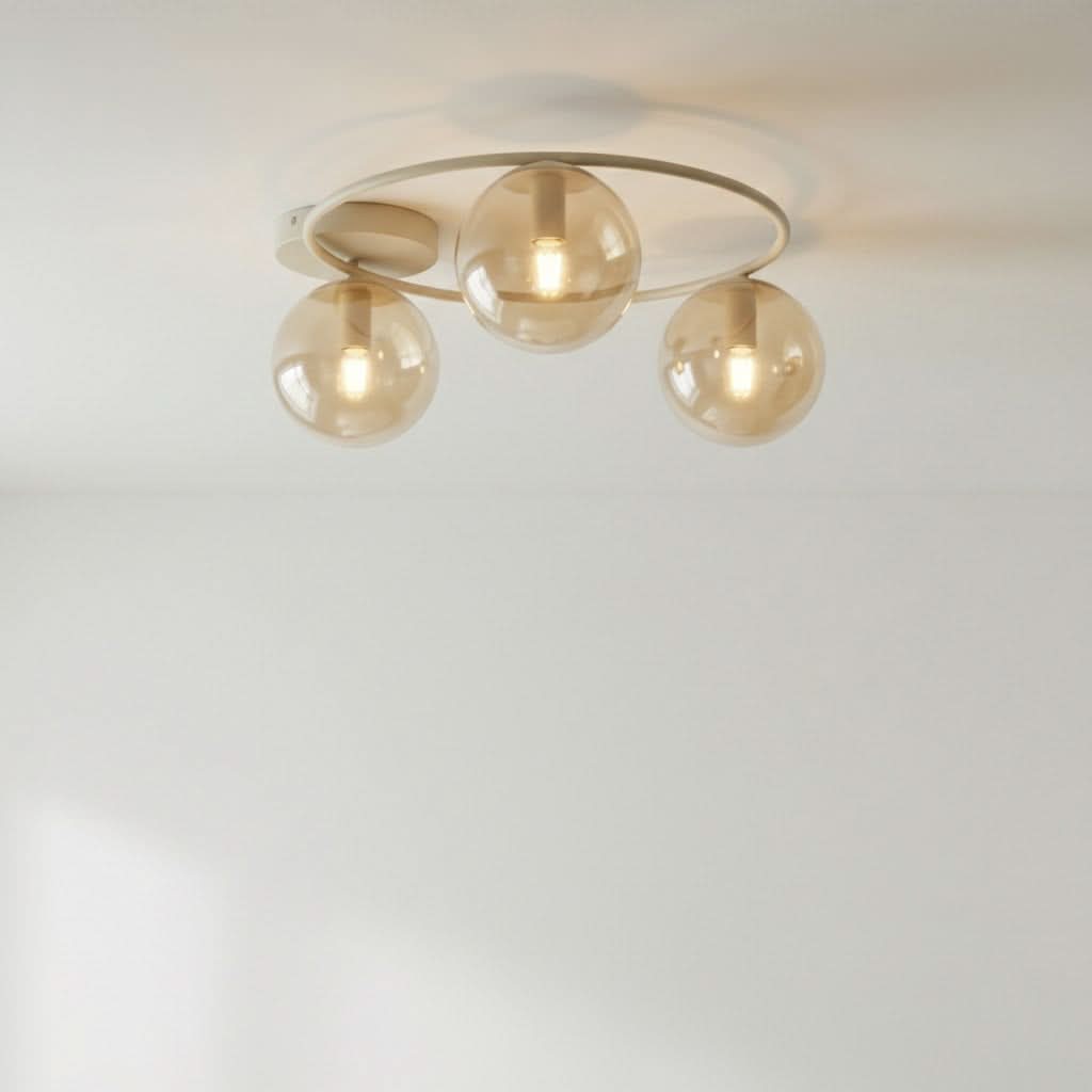 Plafonnier beige fixé au plafond blanc, trois globes ambrés allumés, vue de face.