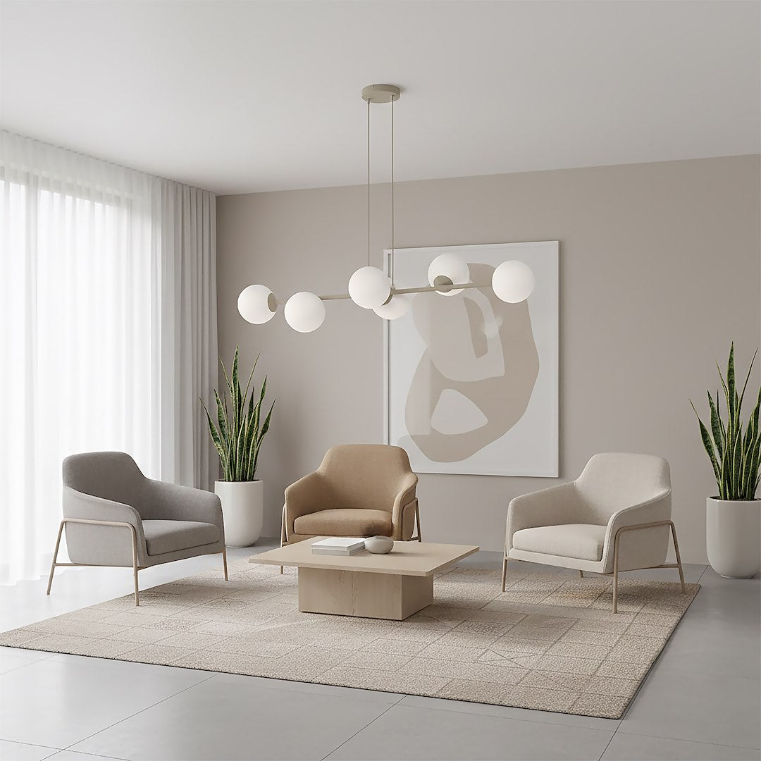 Mise en ambiance salon beige avec trois fauteuils, tapis clair et suspension allumée