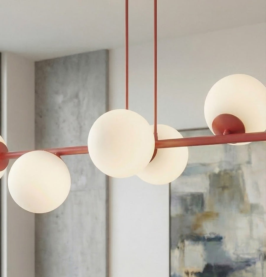 Gros plan sur les globes en verre blanc et la finition bordeaux du luminaire