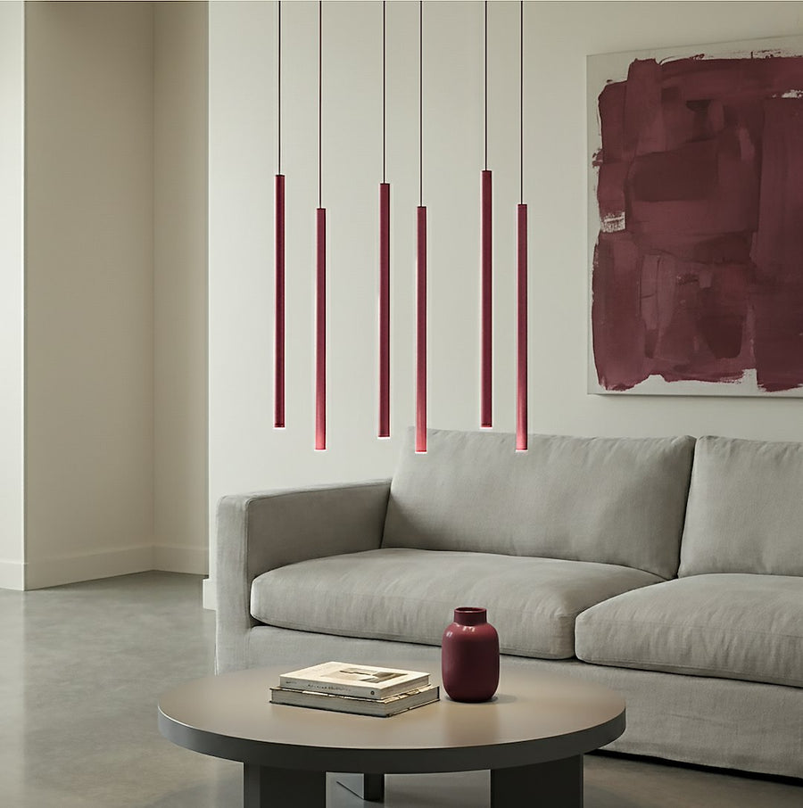 Mise en scène au-dessus d'un canapé gris, tableau lie-de-vin et vase assorti.