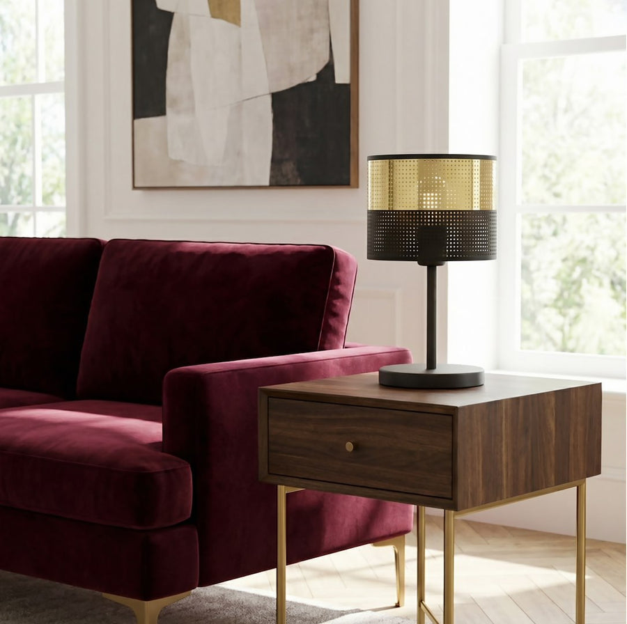 Lampe posée sur une table de chevet en noyer devant un canapé bordeaux