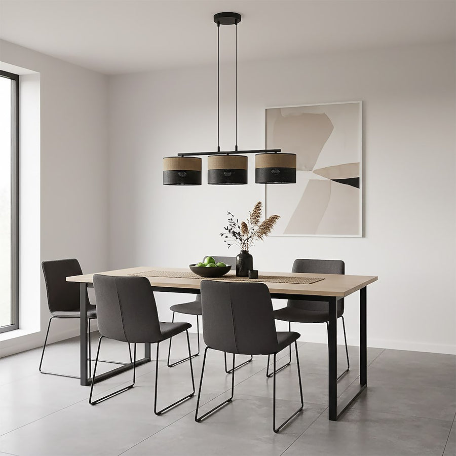 Pièce à vivre claire avec table en bois clair, chaises noires et luminaire à trois cylindres