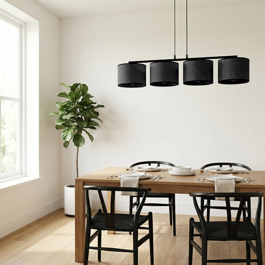 Salle à manger lumineuse : le luminaire éclaire une table en bois entourée de chaises noires.