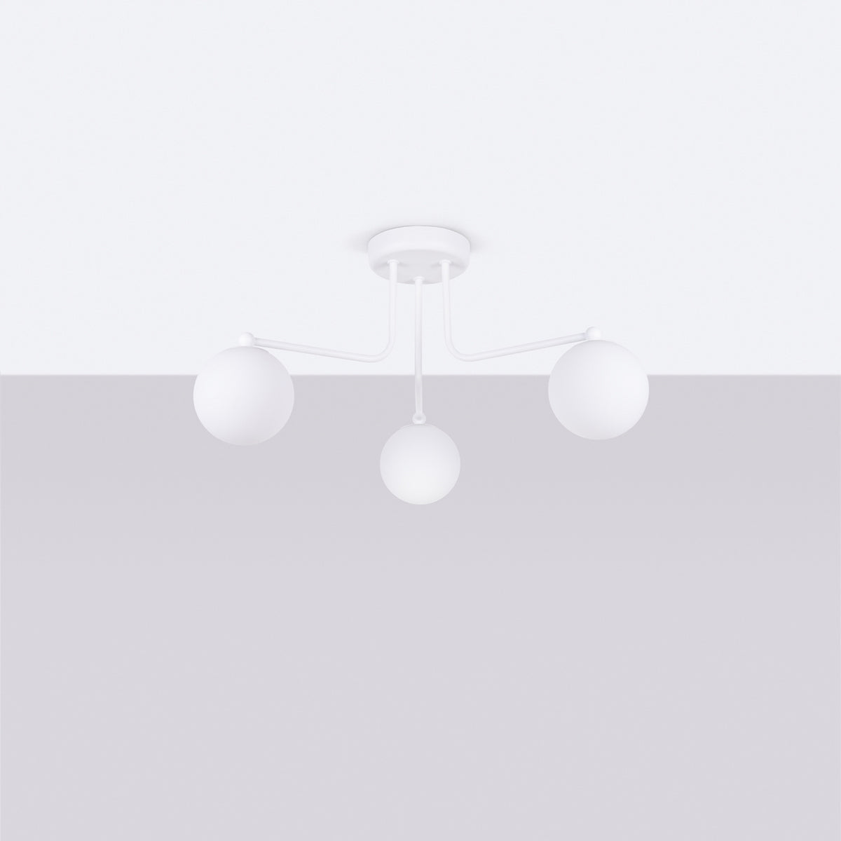 Luminaire fixé au plafond, trois globes blancs opalins, éclairage éteint, vue en légère contre-plongée.