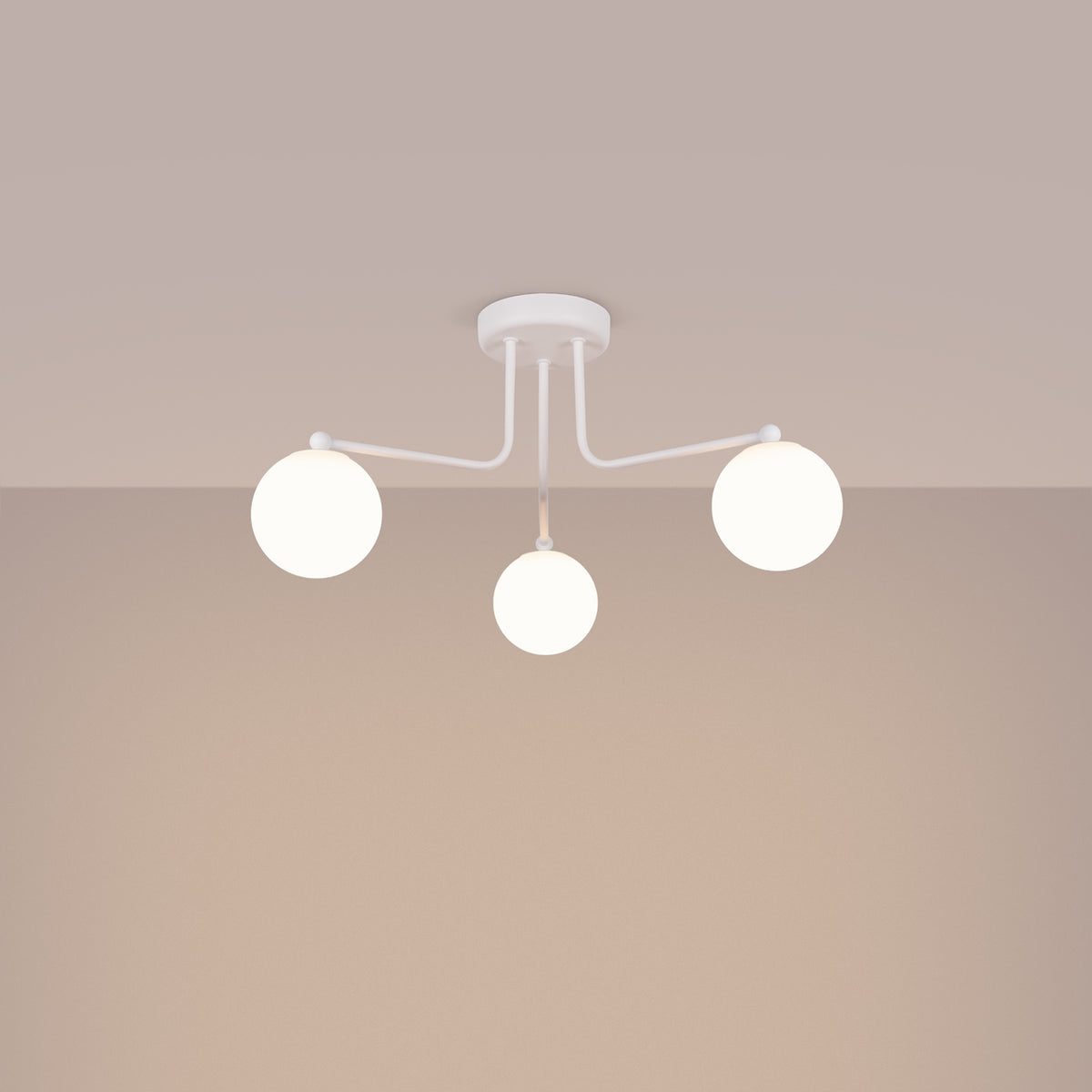 Plafonnier blanc allumé dans une pièce beige, trois globes lumineux diffusent une lumière chaude.