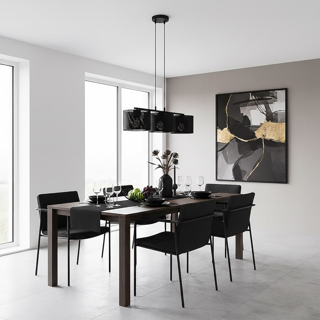 Vue d'ensemble du lustre noir au-dessus d'une table dressée, grande toile dorée au mur