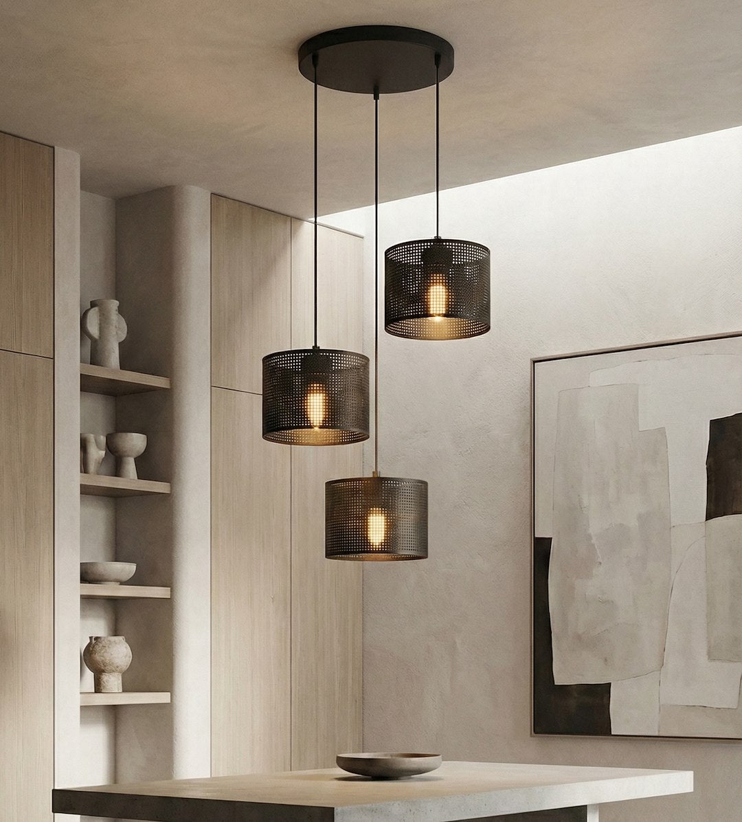 Trois lumières suspendues au-dessus d'une table, intérieur beige, étagères en bois.