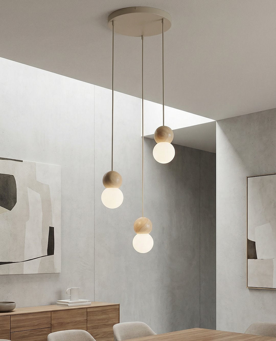 Ambiance salle à manger minimaliste, mur béton gris, suspension allumée au-dessus table.