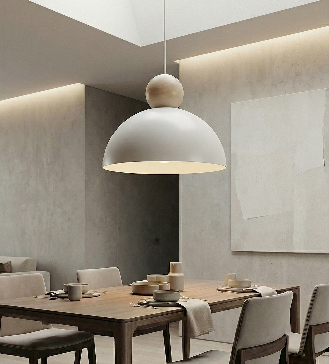 Mise en ambiance salle à manger, suspension allumée au-dessus d'une table en bois dressée.