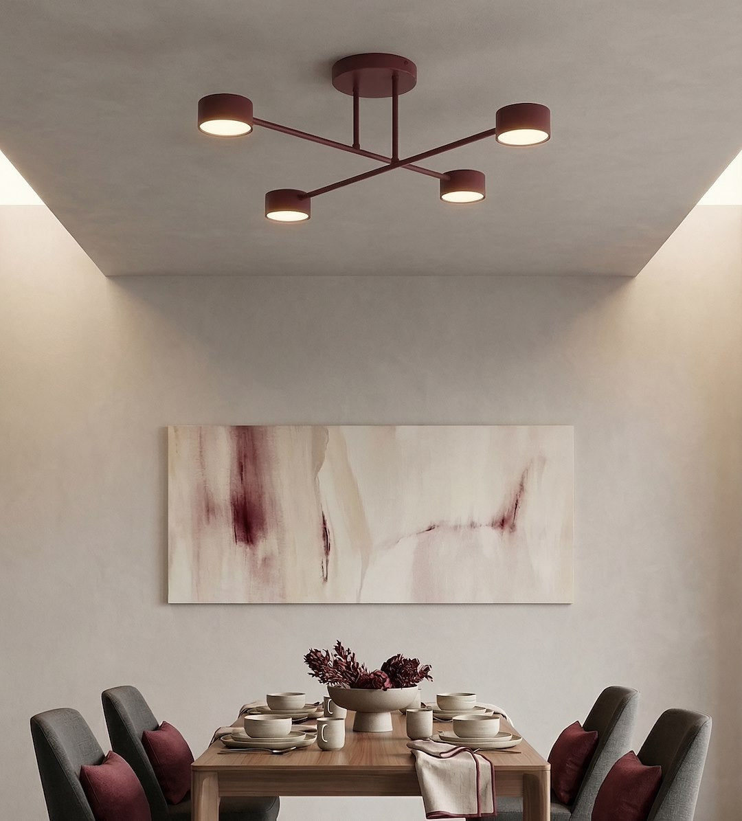 Mise en ambiance au-dessus d'une table de salle à manger en bois, décor floral bordeaux