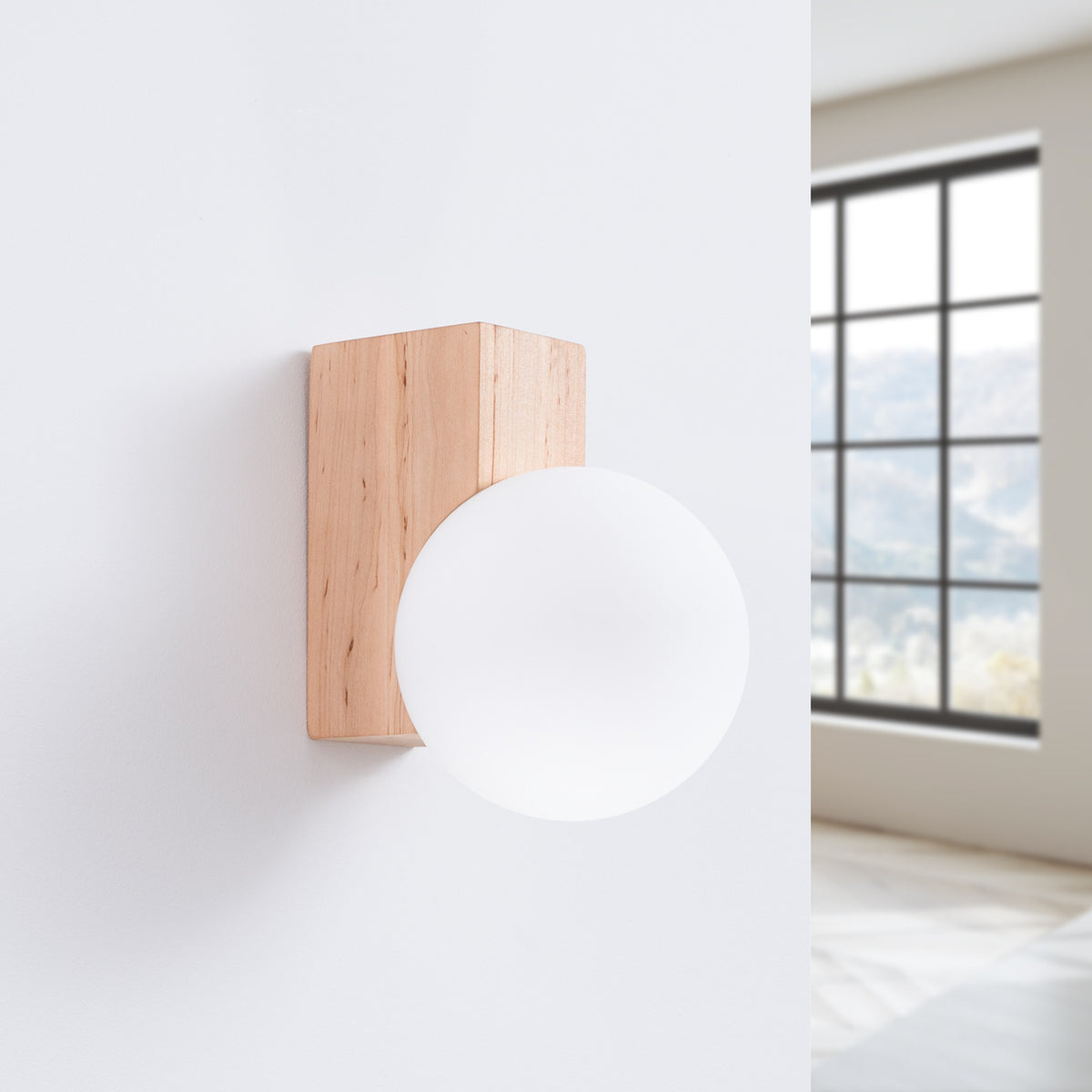Vue de biais montrant le globe blanc devant le support en bois rectangulaire.