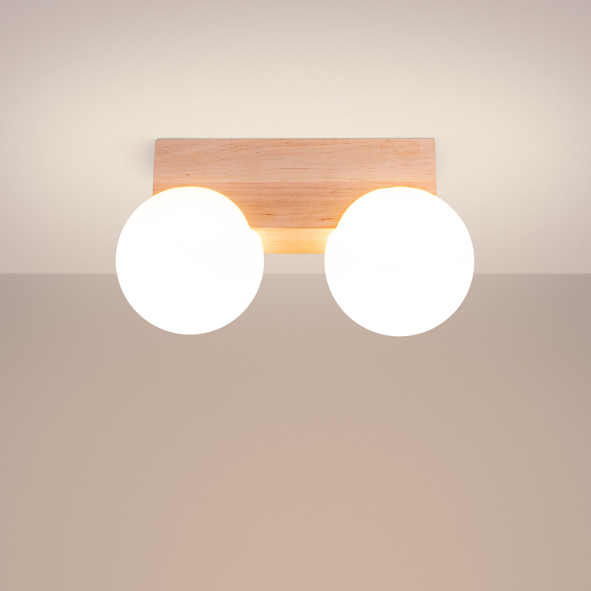 Plafonnier allumé diffusant une lumière chaude sur un plafond blanc.