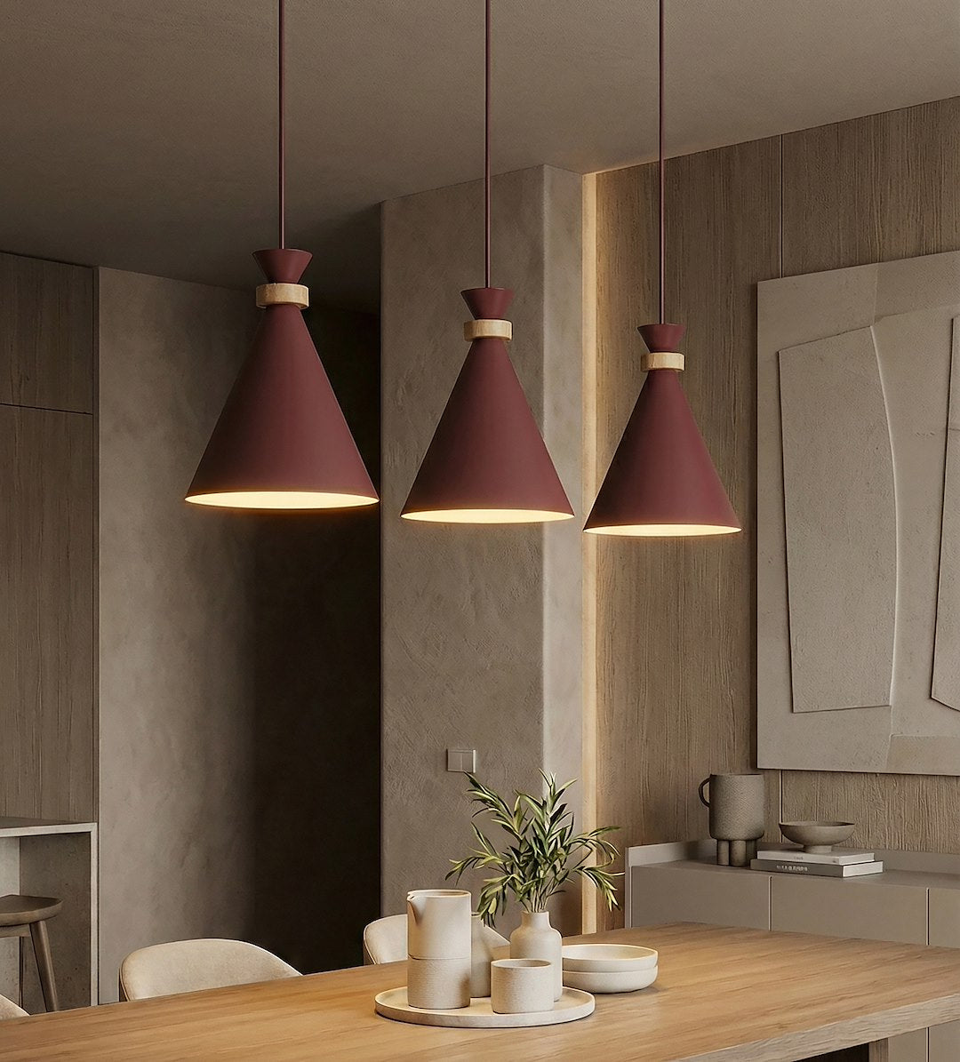 Mise en ambiance au-dessus d'une table en bois, cônes bordeaux allumés dans un intérieur