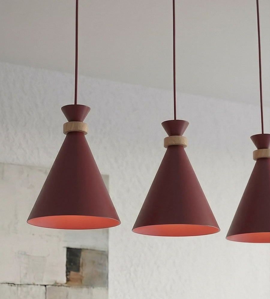 Détail rapproché des abat-jours coniques bordeaux et de leur bague en bois