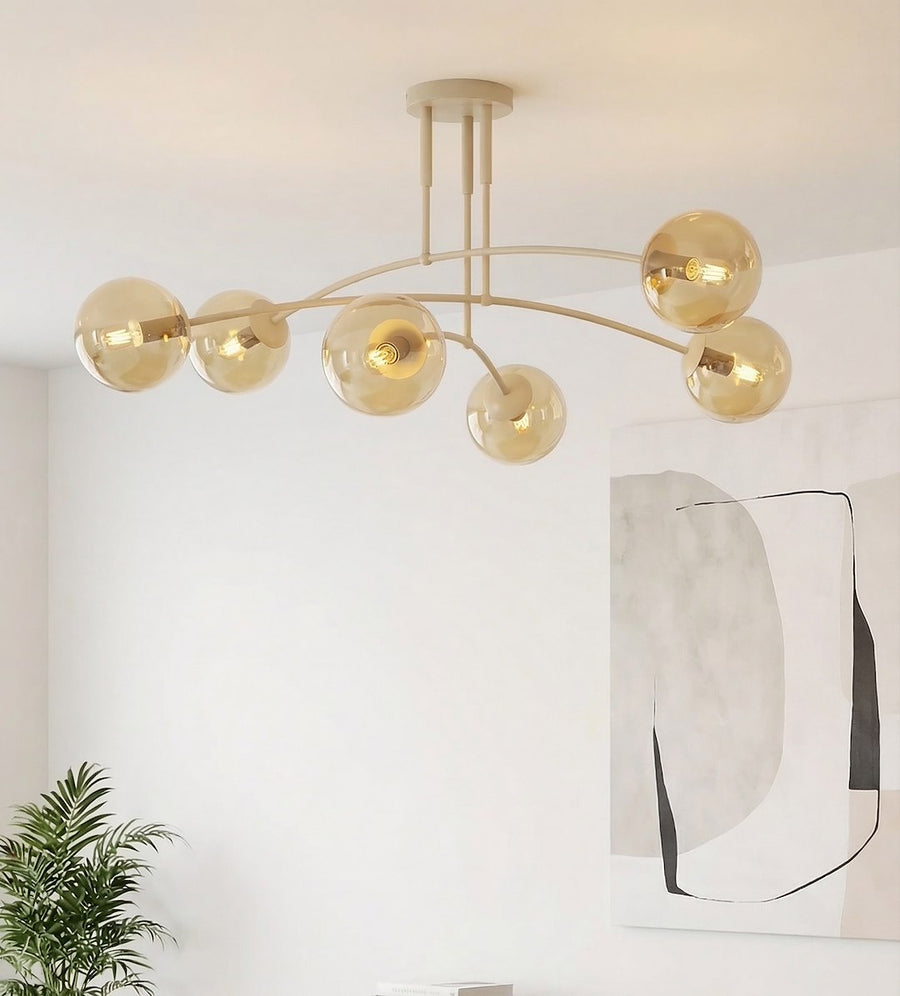 Détail des globes ambrés allumés près d'un tableau et d'une plante