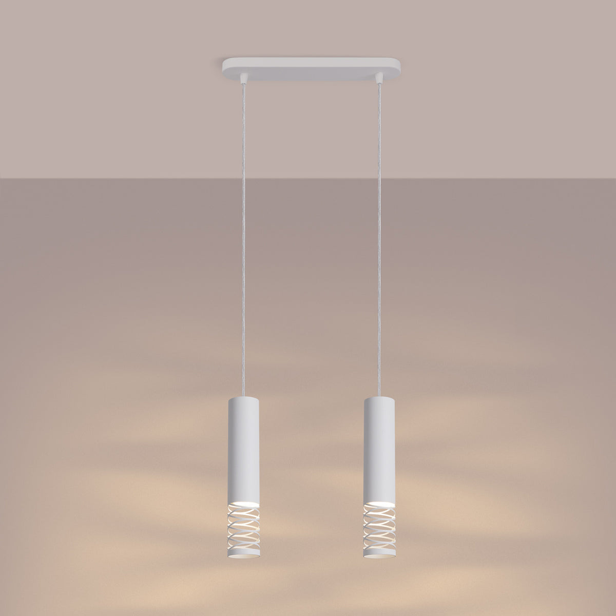 Ambiance chaleureuse où les deux cylindres suspendus diffusent une lumière dorée