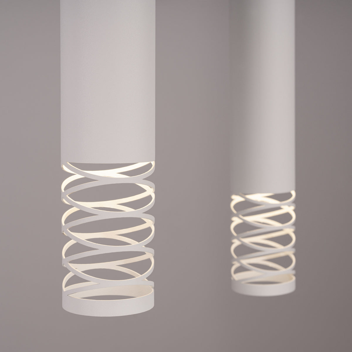 Détail rapproché de la spirale lumineuse allumée sous chaque cylindre blanc