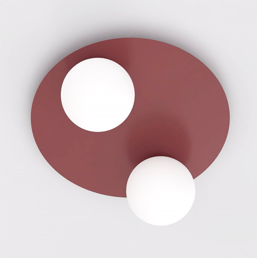 Vue de dessus du plafonnier rond bordeaux et de ses deux globes en verre blanc.