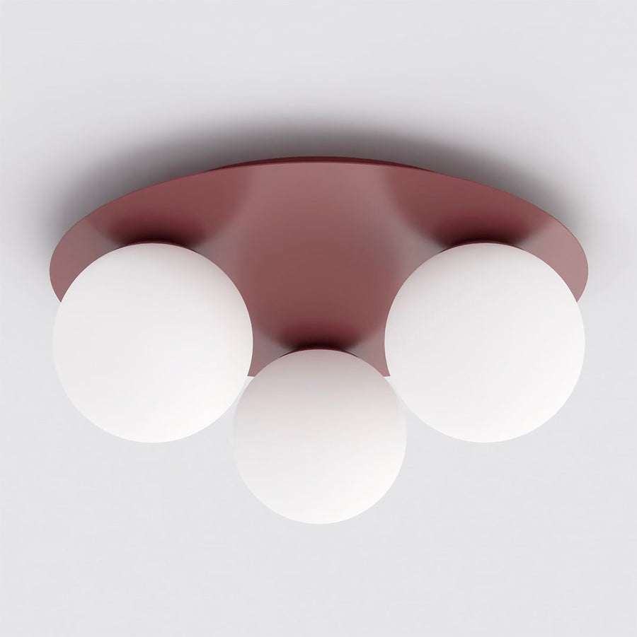 Vue de face du plafonnier bordeaux équipé de trois globes en verre blanc opalin