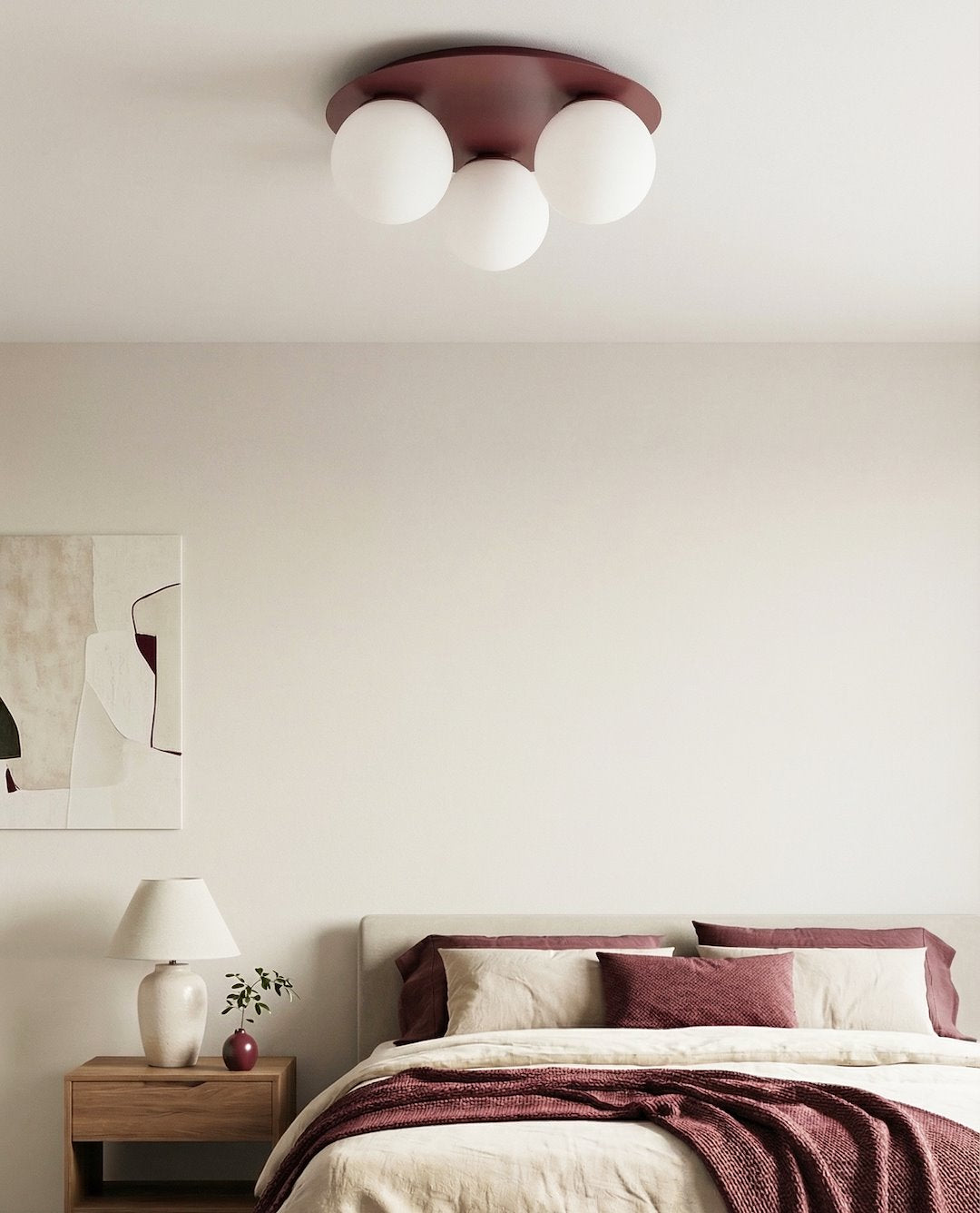 Mise en ambiance dans une chambre claire avec lit, table de chevet et tableau