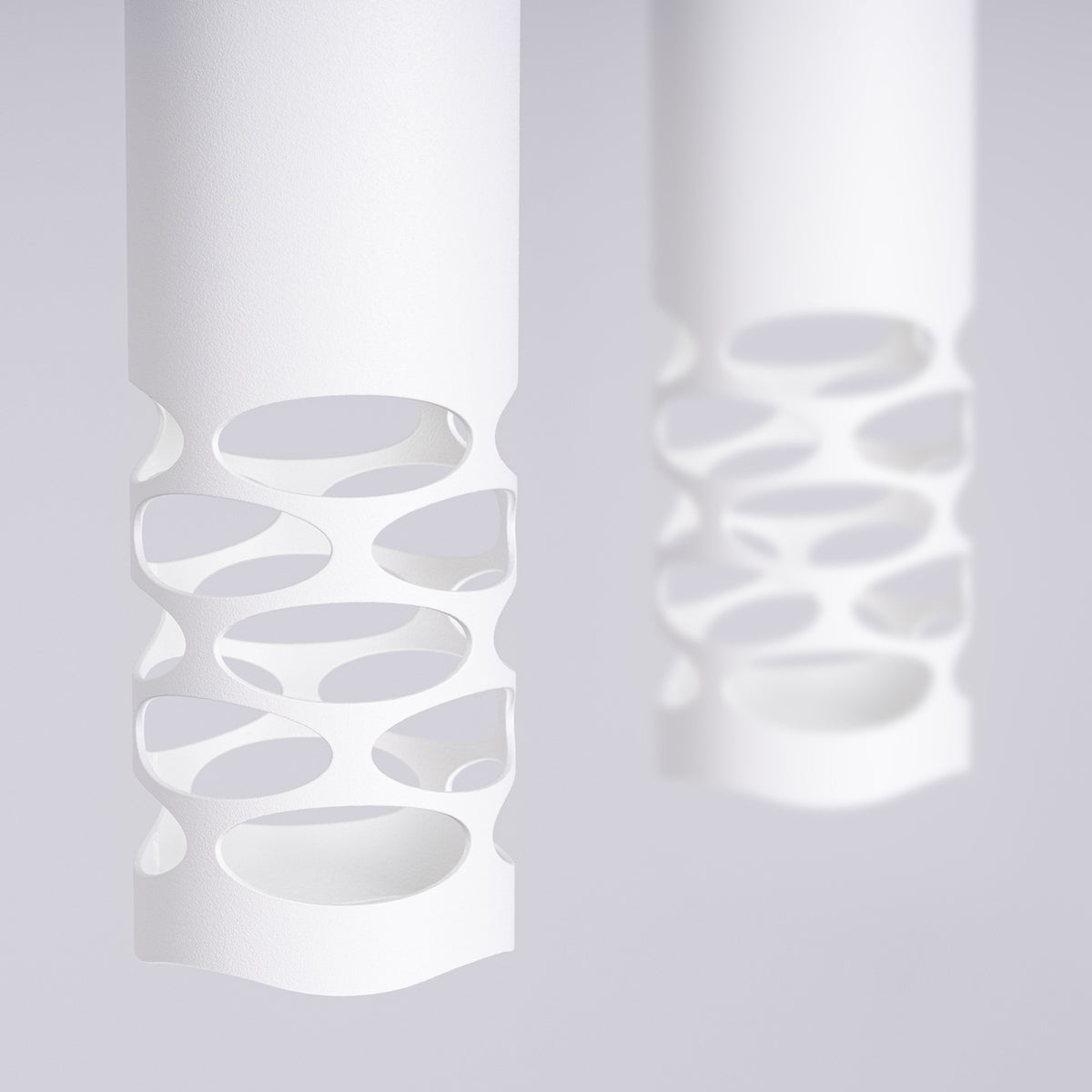 Détail rapproché des perforations blanches et de la lumière diffuse
