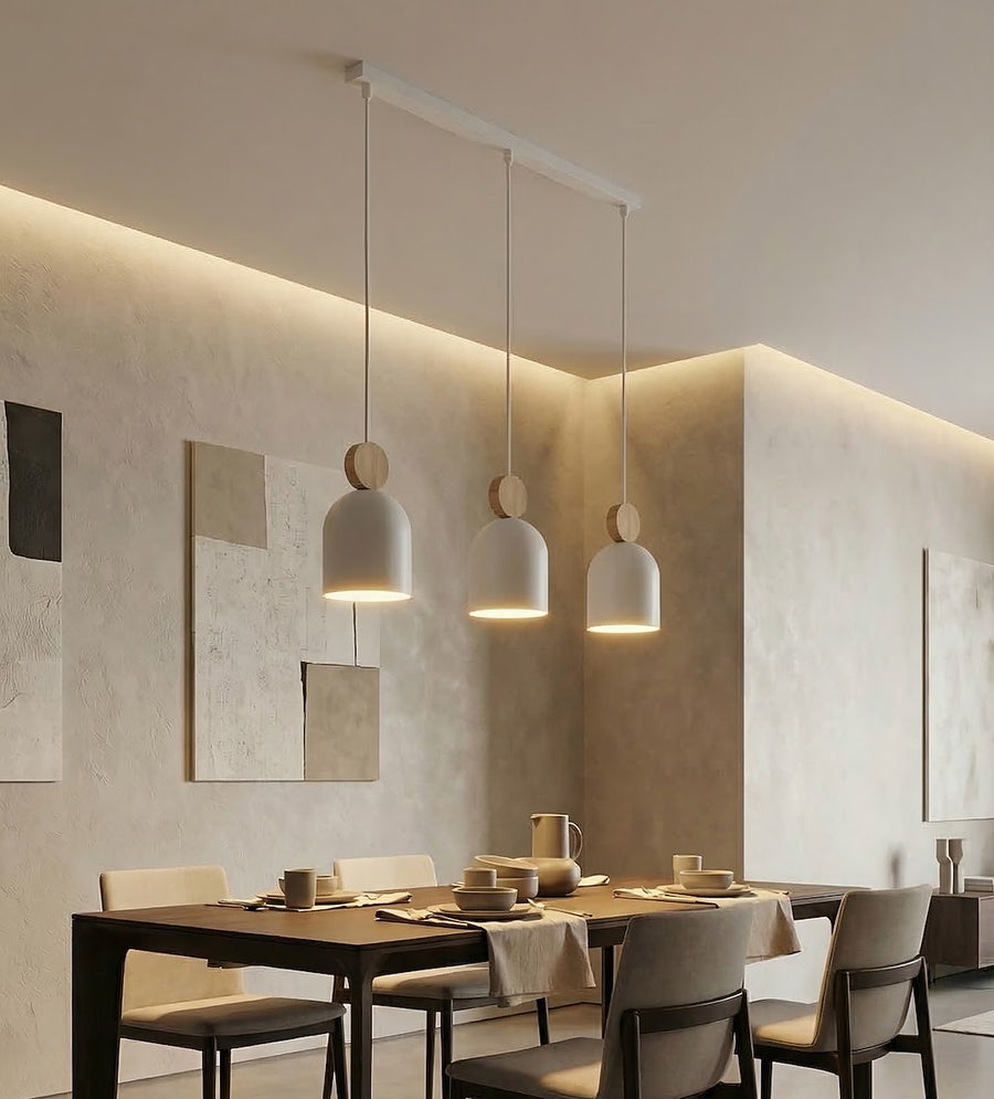Suspension éclairée au-dessus d'une table à manger dressée dans un intérieur beige chaleureux