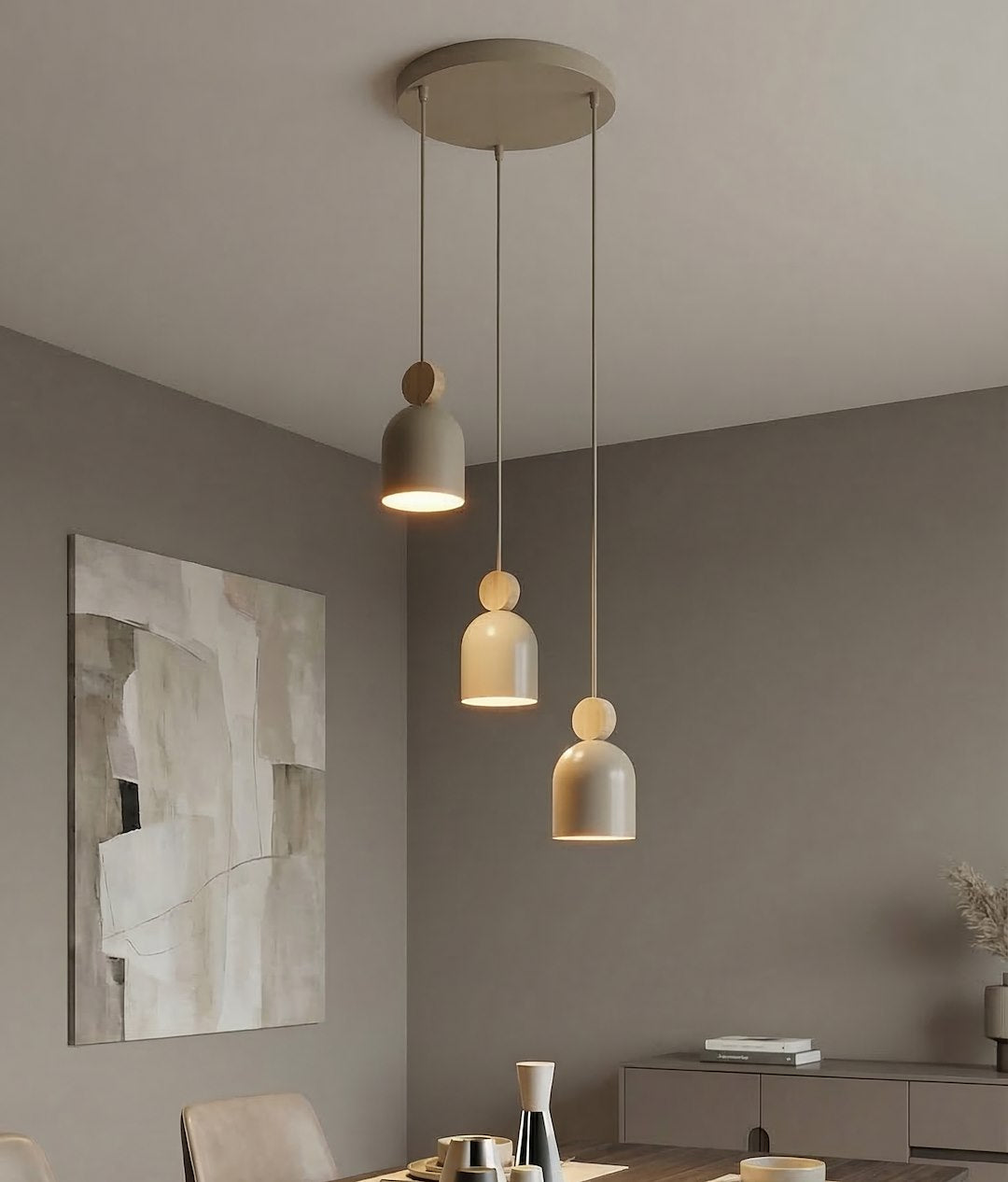 Suspension beige allumée éclairant une salle à manger au mur gris et tableau