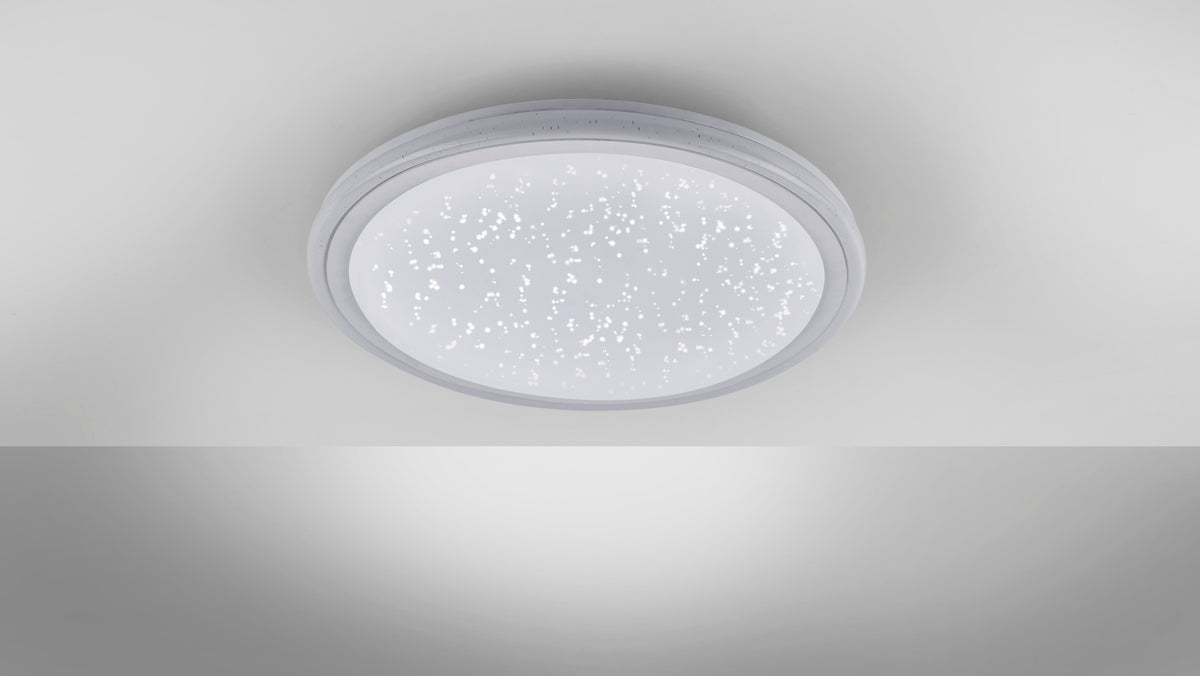 Plafonnier blanc allumé au plafond diffusant une lumière étoilée