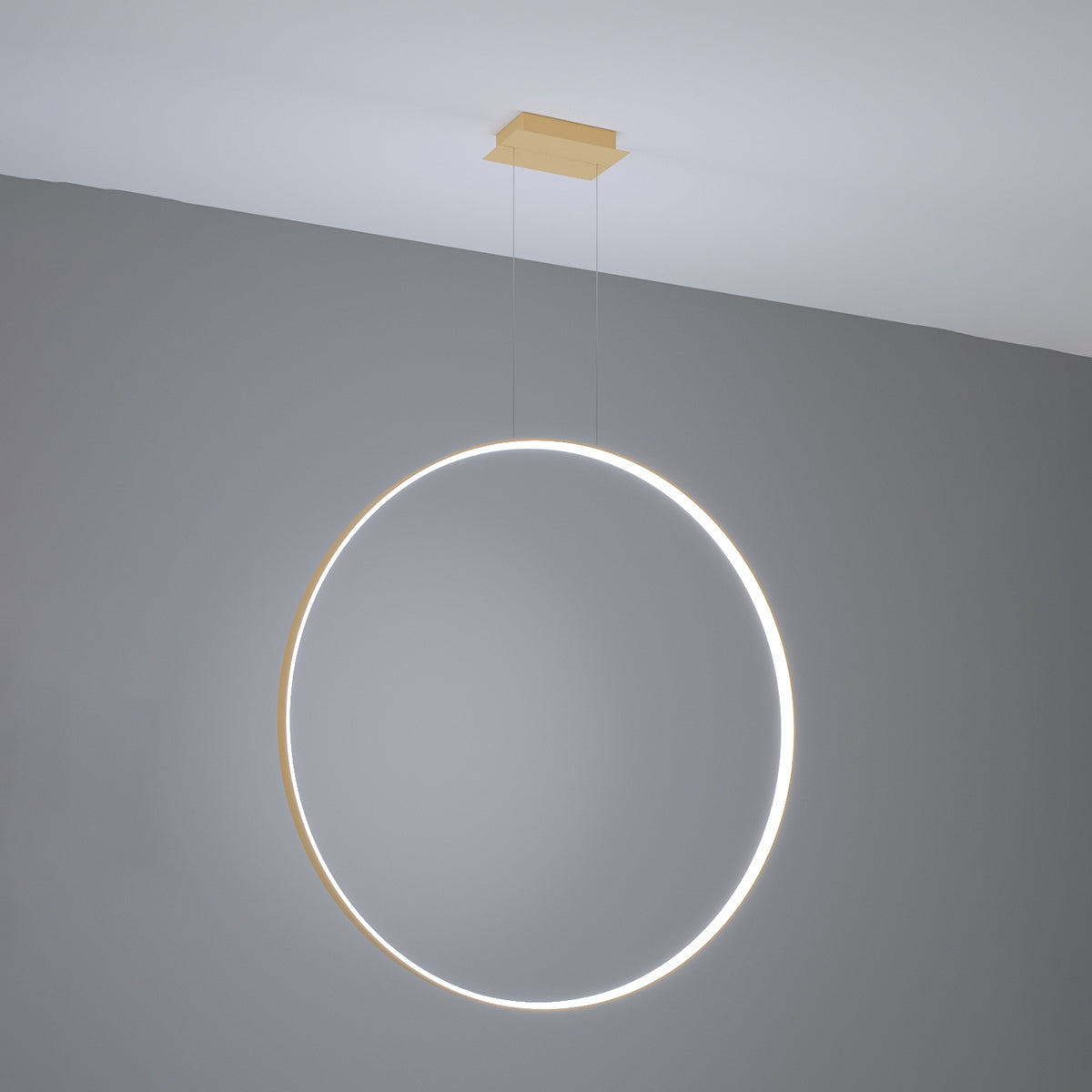 Anneau lumineux allumé diffusant un halo blanc devant un mur gris