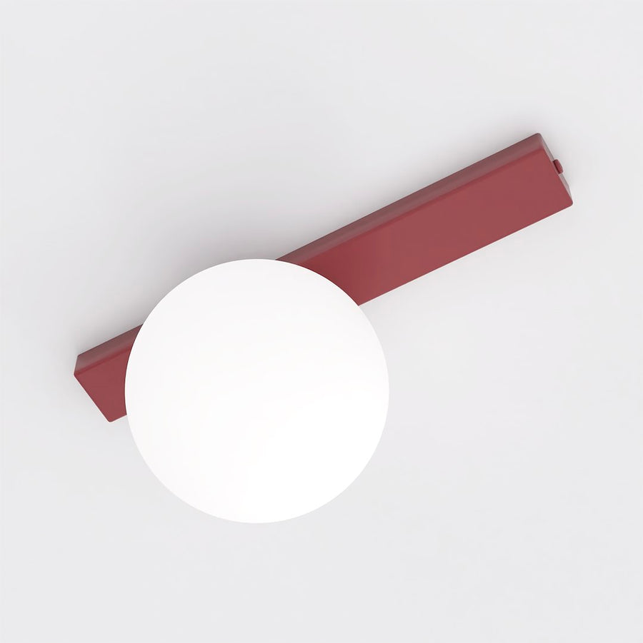 Vue en plongée montrant la barre rectangulaire rouge et la sphère blanche opaline