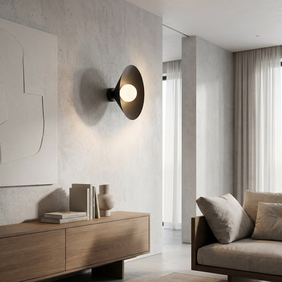 Applique allumée dans un salon contemporain, près d'un canapé beige et d'une tenture