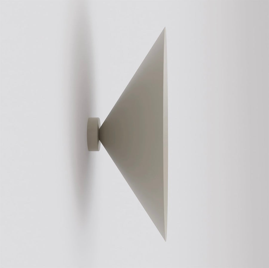 Vue de profil de l'applique murale beige à abat-jour conique orienté vers l'extérieur.