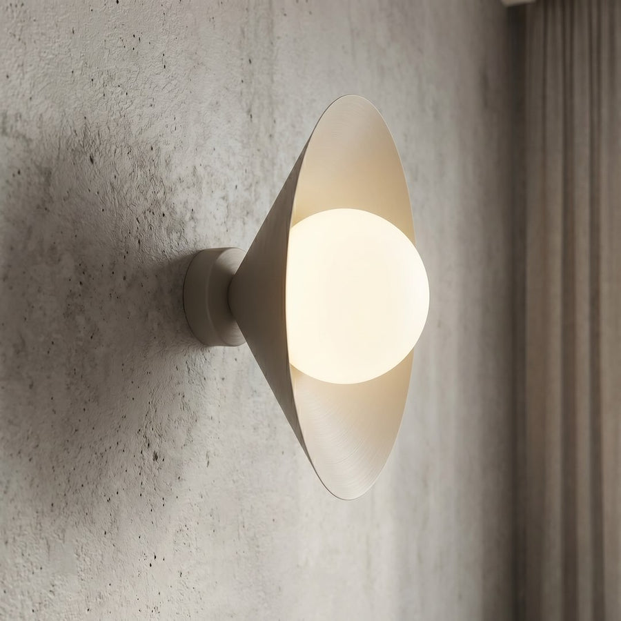 Détail rapproché de la sphère en verre blanc éclairée et du cône beige.