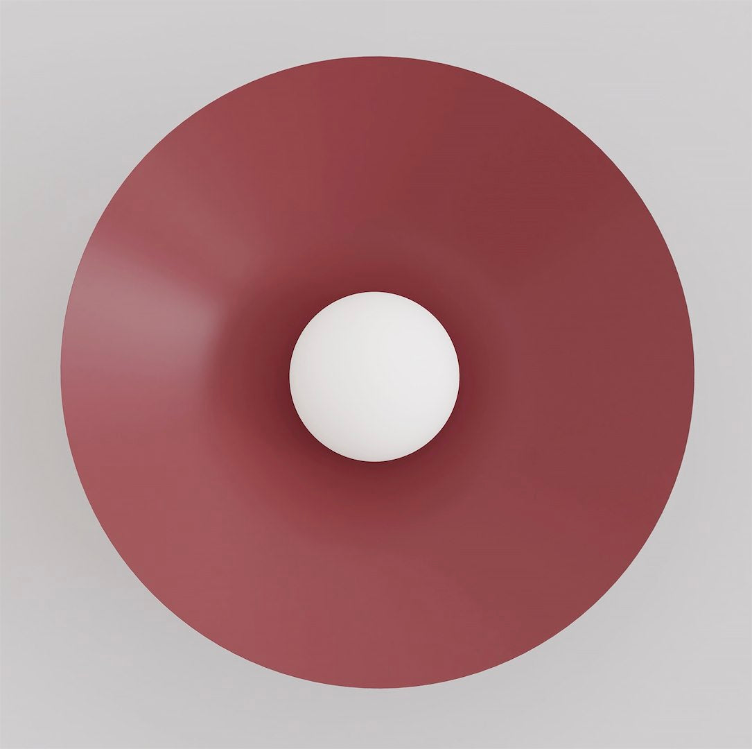 Vue de face du grand disque bordeaux avec sphère de verre blanc centrée