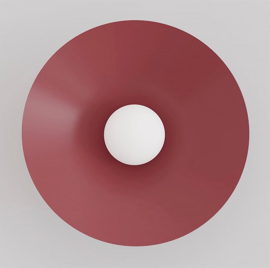 Vue de face du grand disque bordeaux avec sphère de verre blanc centrée