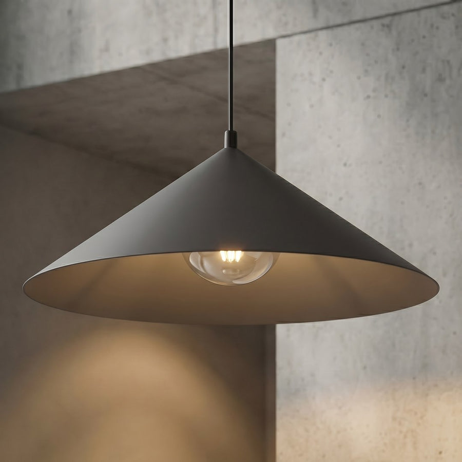 Gros plan sur l'ampoule allumée, l'intérieur graphite et le mur en béton.