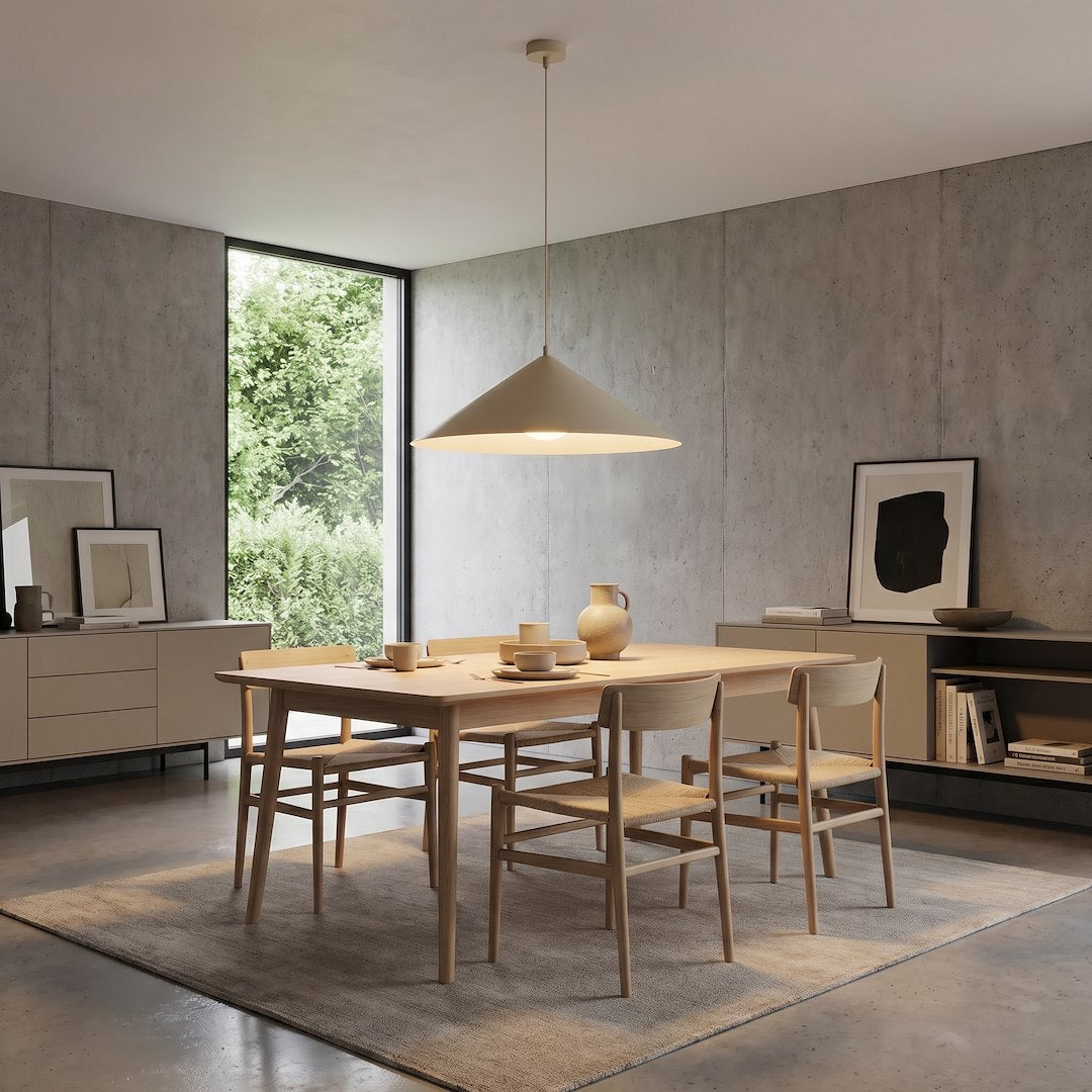 Suspension allumée éclairant une table en bois dans une pièce minimaliste