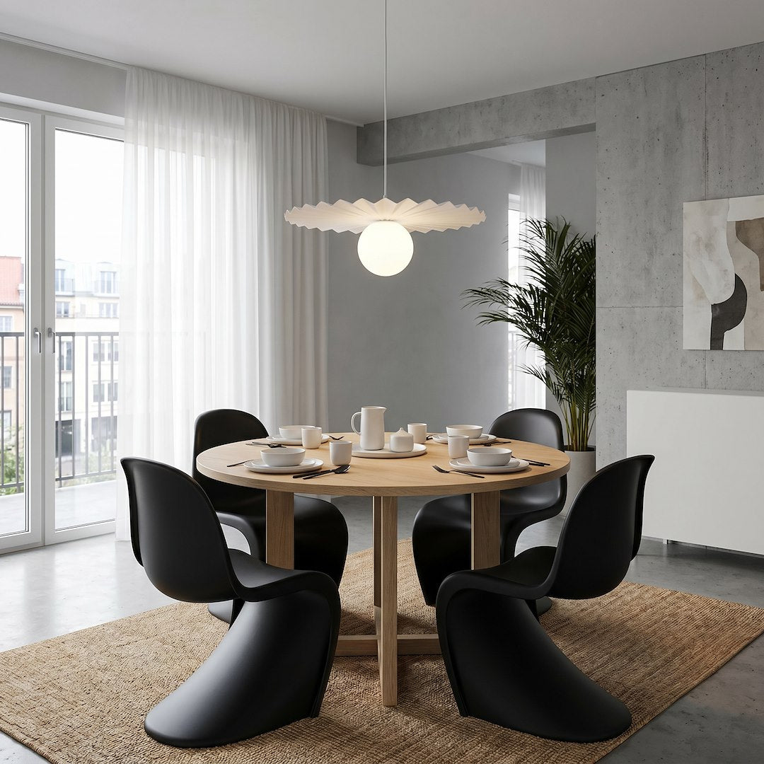 Vue d'ensemble du luminaire suspendu éclairé au-dessus d'une table ronde et chaises noires