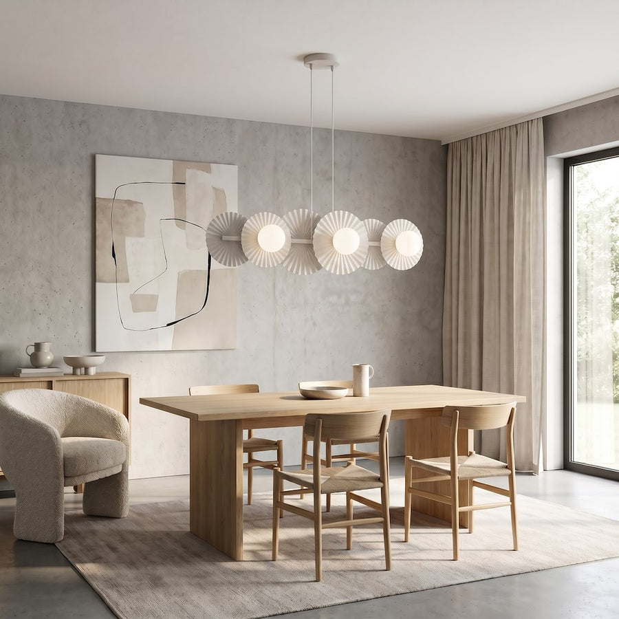 Intérieur clair avec table en chêne, fauteuil bouclé, rideaux beiges et grande fenêtre